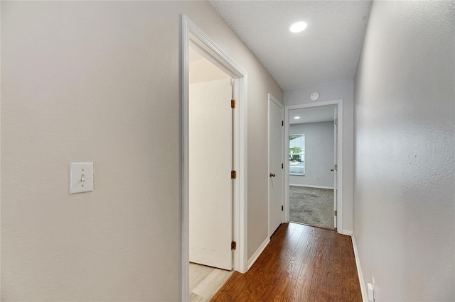 hallway featuring a textured ceiling and wood-type flooring