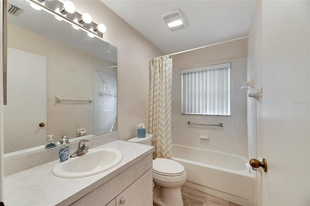 full bathroom with vanity, hardwood / wood-style floors, shower / tub combo with curtain, and toilet