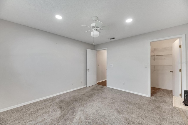 spare room featuring a textured ceiling, carpet flooring, and ceiling fan