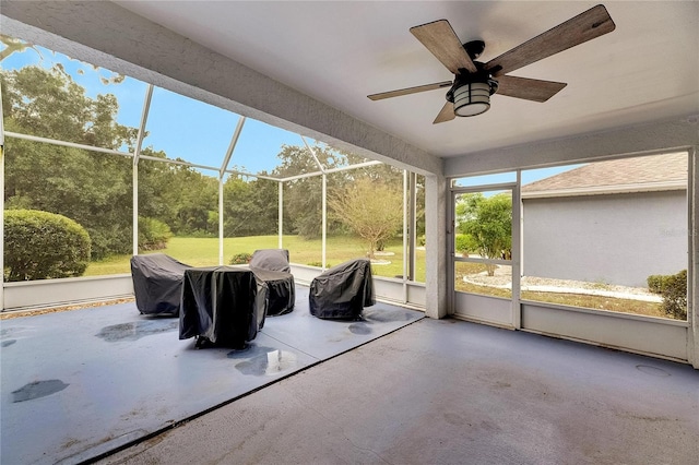 unfurnished sunroom with ceiling fan