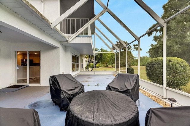 view of patio with a balcony, a grill, and a lanai