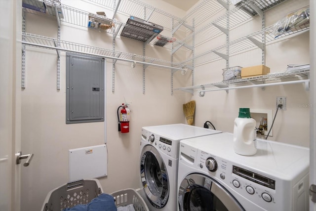 washroom featuring electric panel and washer and clothes dryer