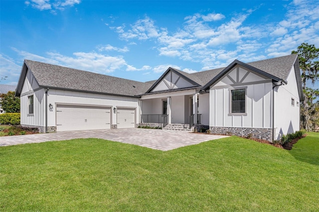 view of front of property with a front yard, covered porch, and a garage