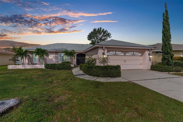 view of front of property featuring a garage and a yard