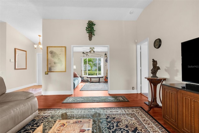 entryway with hardwood / wood-style flooring, lofted ceiling, and ceiling fan with notable chandelier