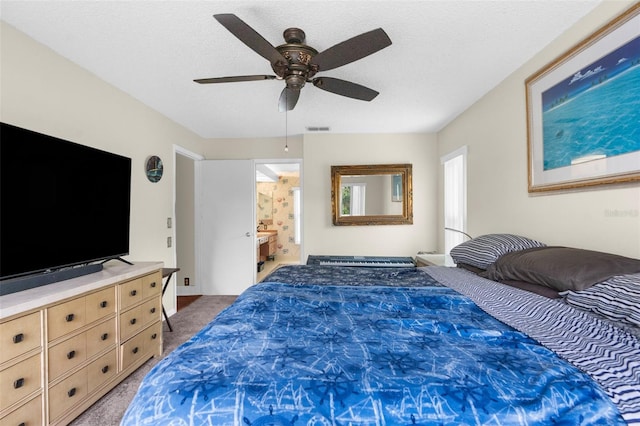 bedroom with ceiling fan, carpet, and a textured ceiling