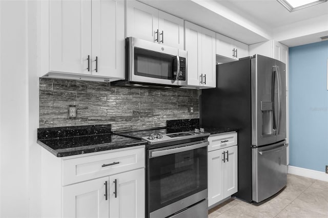 kitchen with dark stone counters, white cabinets, and appliances with stainless steel finishes