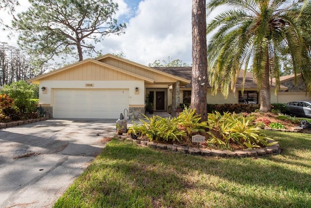 single story home featuring a front lawn and a garage