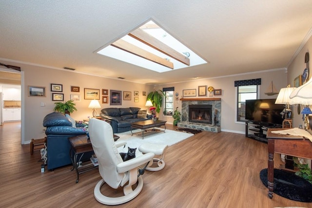 living room featuring ornamental molding, hardwood / wood-style floors, a healthy amount of sunlight, and a skylight