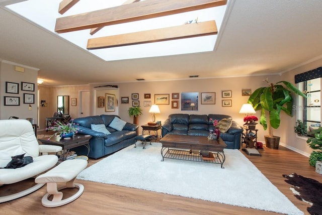 living room with hardwood / wood-style floors, crown molding, and a skylight