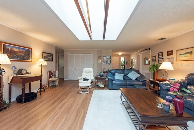 living room with ornamental molding, hardwood / wood-style floors, and a skylight