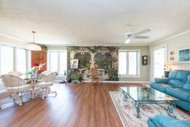 living room with ornamental molding, hardwood / wood-style floors, a textured ceiling, and ceiling fan