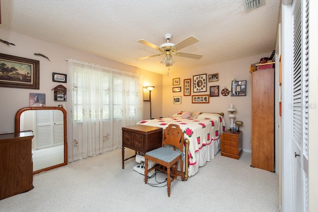 carpeted bedroom with a textured ceiling and ceiling fan