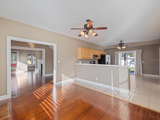 unfurnished living room featuring a ceiling fan, light wood-type flooring, plenty of natural light, and baseboards