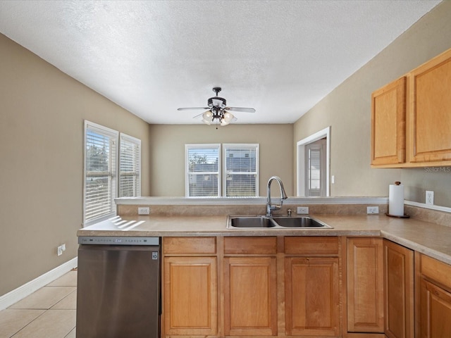 kitchen with kitchen peninsula, stainless steel dishwasher, a textured ceiling, sink, and light tile patterned flooring