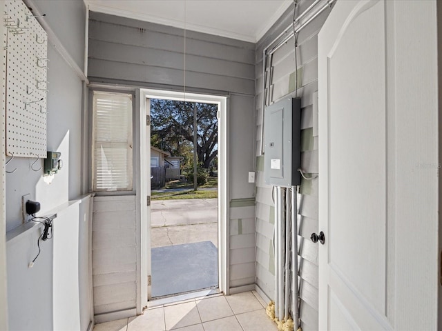 doorway to outside with electric panel, light tile patterned floors, and ornamental molding