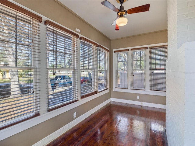 unfurnished sunroom featuring ceiling fan