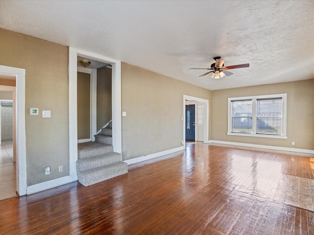 unfurnished living room with ceiling fan, wood-type flooring, and a textured ceiling