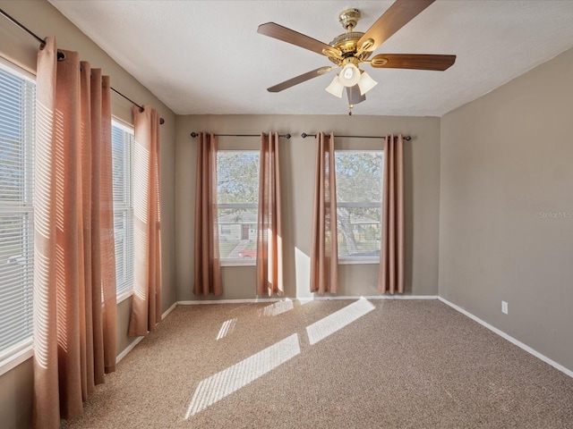 carpeted empty room with ceiling fan and a healthy amount of sunlight