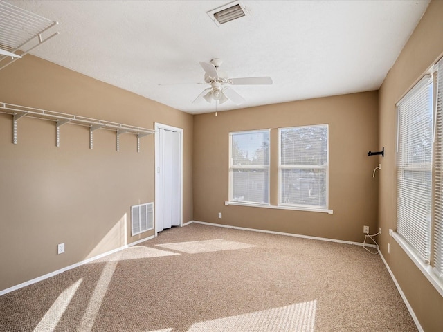 unfurnished room with ceiling fan and carpet floors