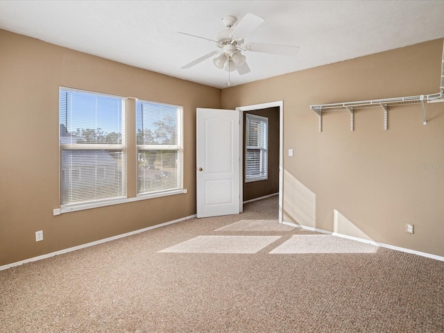 carpeted spare room featuring ceiling fan