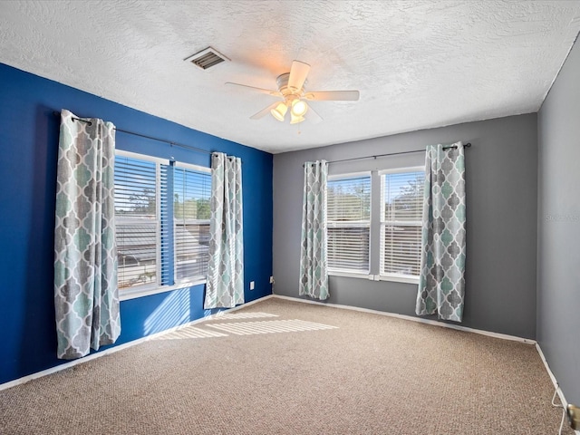 spare room with carpet flooring, ceiling fan, and plenty of natural light