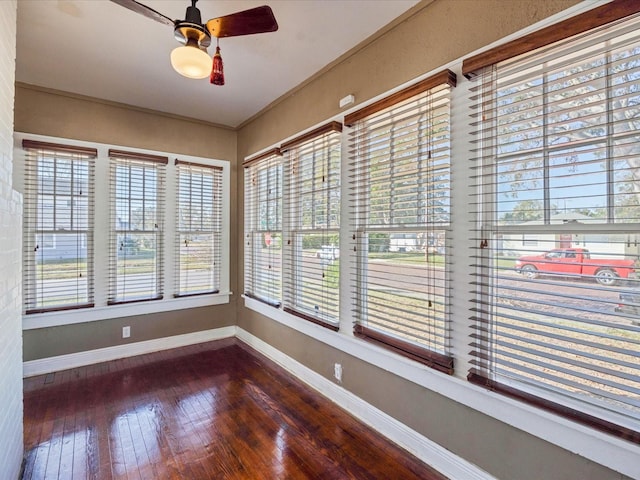 unfurnished sunroom featuring a ceiling fan