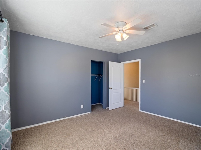 unfurnished bedroom featuring a textured ceiling, carpet, visible vents, and baseboards