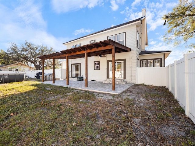 back of property with a balcony, a fenced backyard, a lawn, and a patio