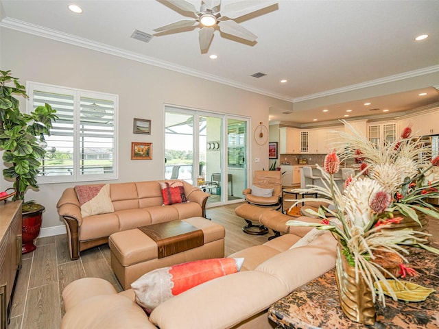 living room with crown molding, light wood-type flooring, and ceiling fan