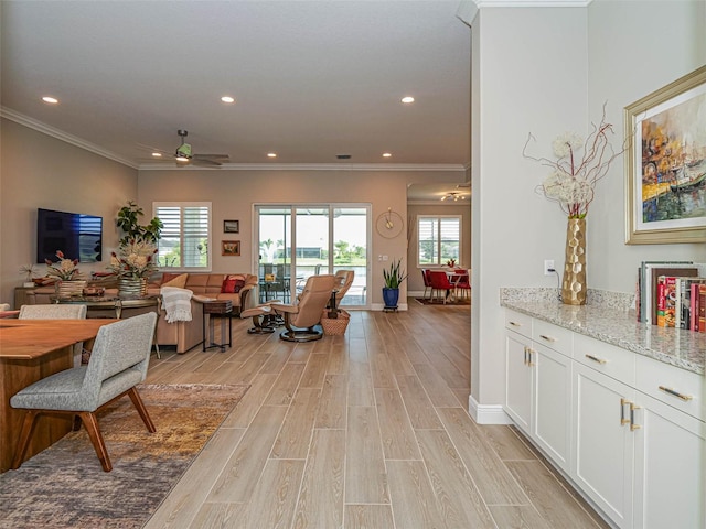 living room featuring crown molding, light wood-type flooring, and ceiling fan