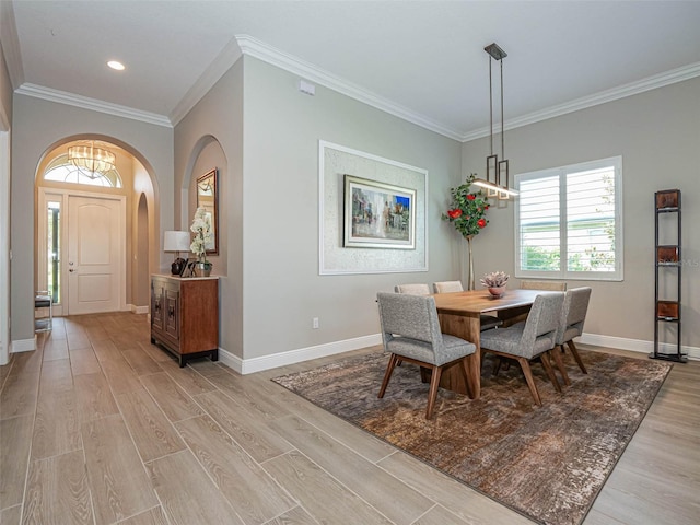 dining space with ornamental molding and light hardwood / wood-style floors