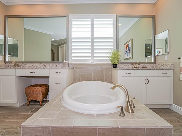 bathroom featuring vanity, hardwood / wood-style floors, tiled tub, and ornamental molding