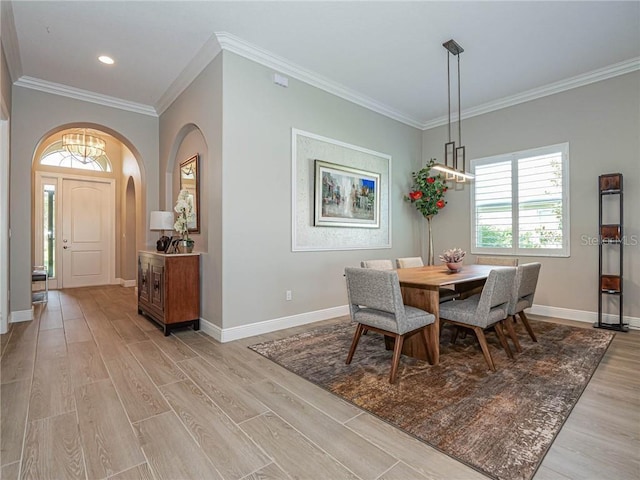 4836 Four Lakes Cir SW, Vero Beach, FL 32968 - dining area featuring ornamental molding, light wood-style flooring, arched walkways, and baseboards