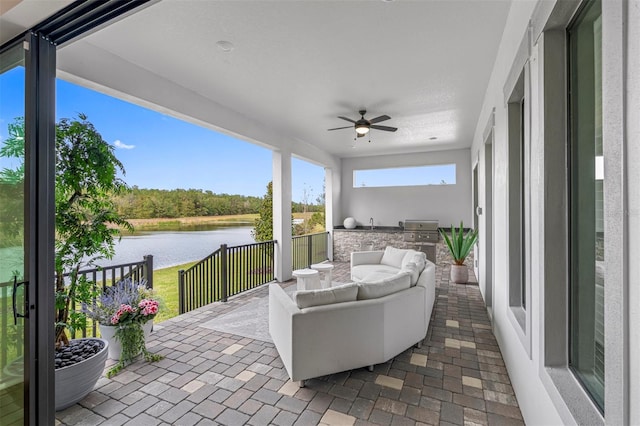 view of patio / terrace featuring an outdoor living space, a water view, and ceiling fan