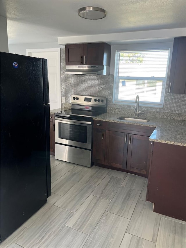 kitchen with tasteful backsplash, stainless steel range with electric cooktop, black refrigerator, and sink