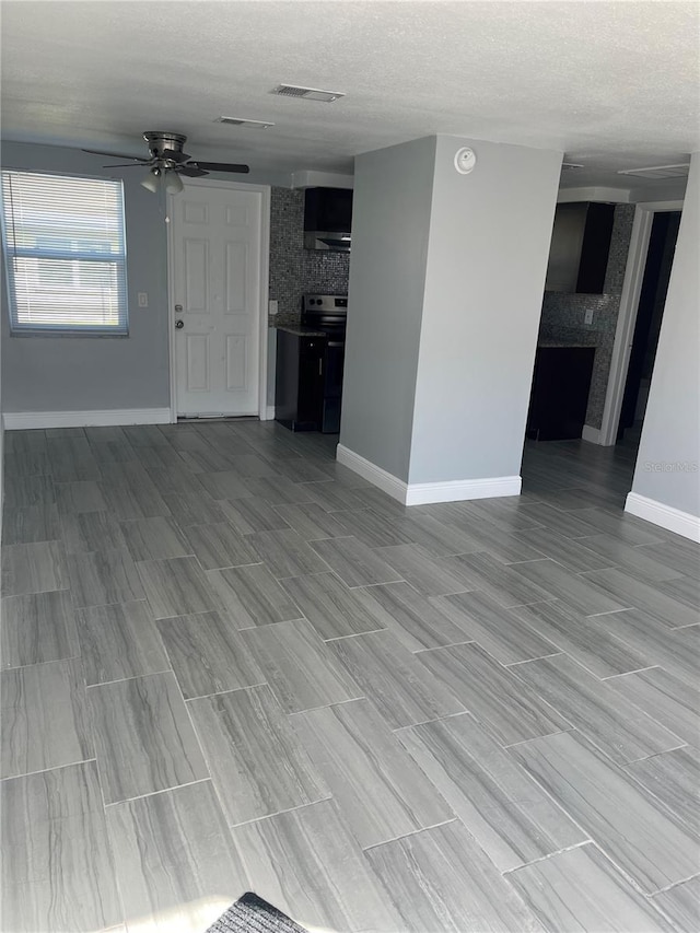 unfurnished living room with ceiling fan, a textured ceiling, light hardwood / wood-style floors, and a fireplace