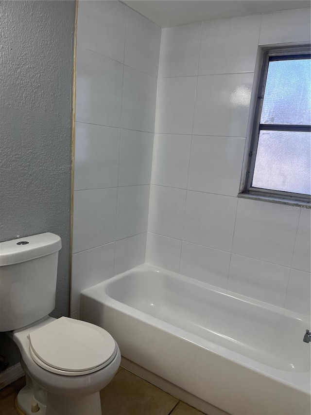 bathroom featuring toilet and tiled shower / bath combo