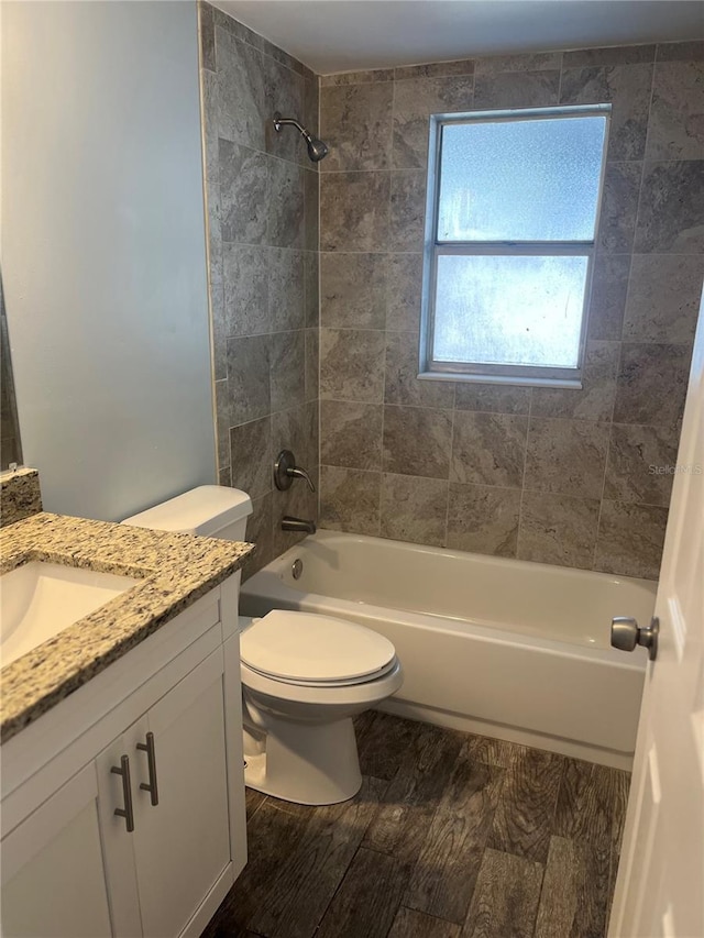 full bathroom featuring vanity, toilet, hardwood / wood-style flooring, and tiled shower / bath combo