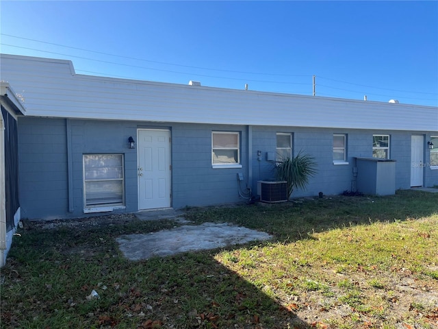 rear view of property featuring cooling unit and a yard