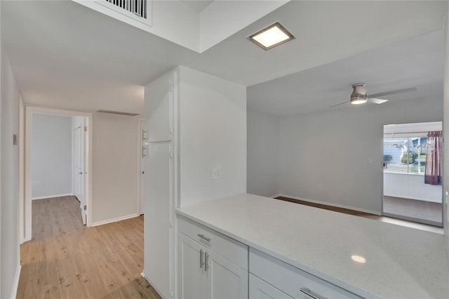 kitchen featuring white cabinets, light hardwood / wood-style flooring, and ceiling fan