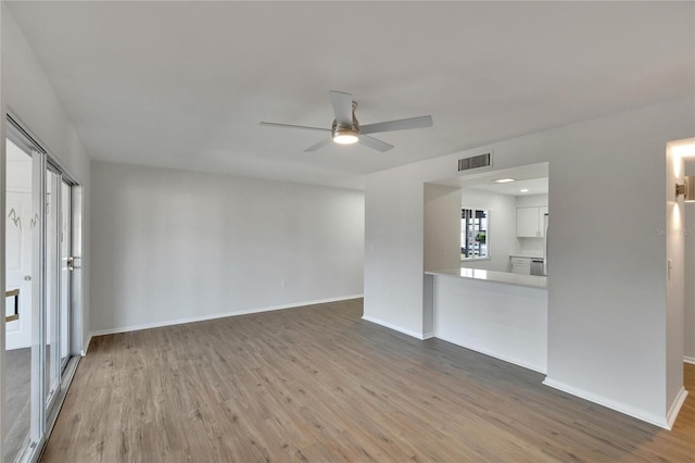 unfurnished living room with wood-type flooring and ceiling fan