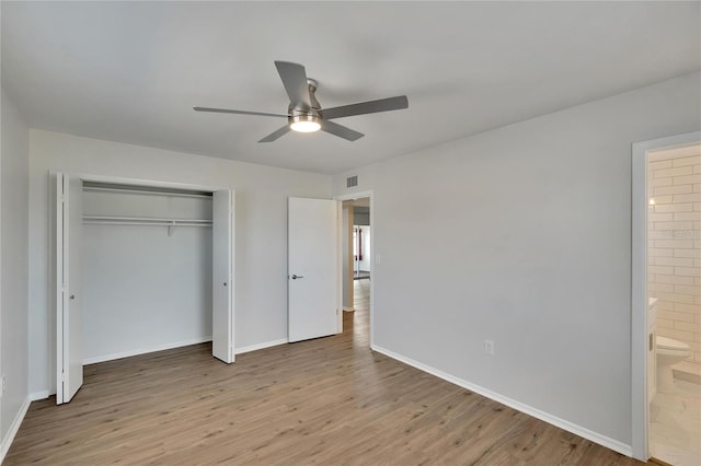 unfurnished bedroom with ensuite bath, light hardwood / wood-style flooring, a closet, and ceiling fan