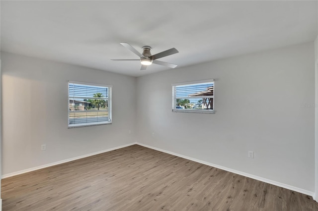 spare room with ceiling fan, plenty of natural light, and light wood-type flooring