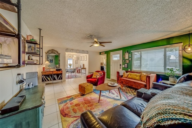 living room featuring light tile patterned flooring, a textured ceiling, and ceiling fan