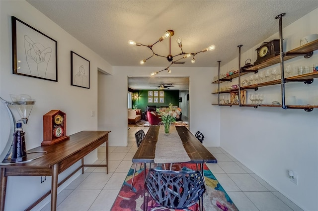 tiled dining space featuring a textured ceiling and ceiling fan with notable chandelier