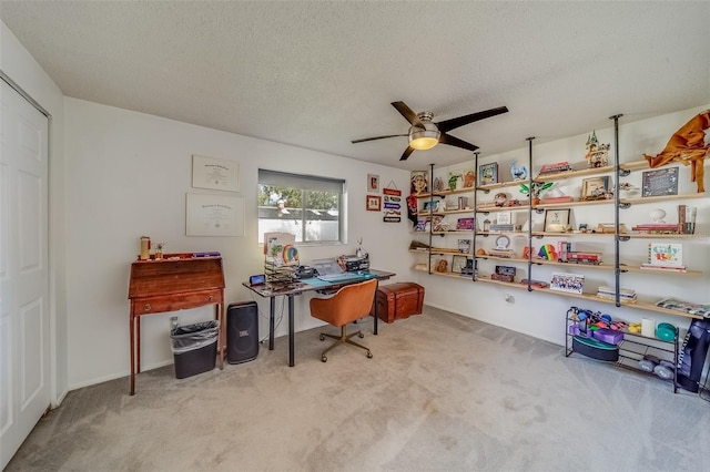 office with a textured ceiling, light colored carpet, and ceiling fan