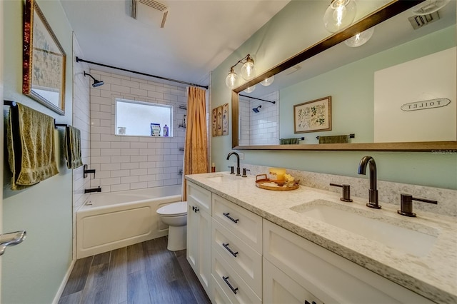 full bathroom featuring shower / bath combo with shower curtain, hardwood / wood-style floors, vanity, and toilet