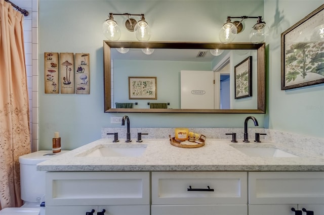 bathroom with vanity, curtained shower, and toilet