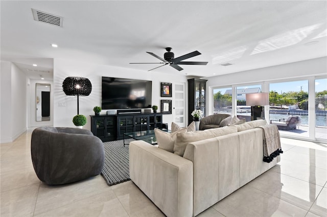 living room featuring ceiling fan, light tile patterned floors, and plenty of natural light